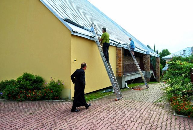 Wymiana uszkodzonych rynien na dachu kościoła